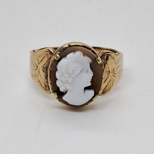 Gold ring with a white cameo on a light gray background