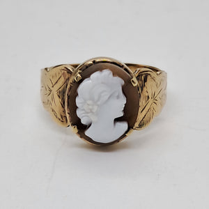 Gold ring with a white cameo on a light gray background